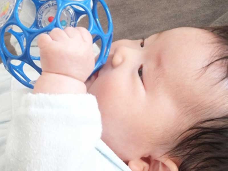 おもちゃを掴んで遊んでいる赤ちゃん