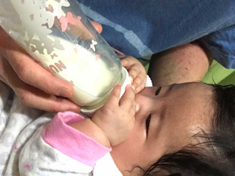 赤ちゃんに授乳をしているお父さん