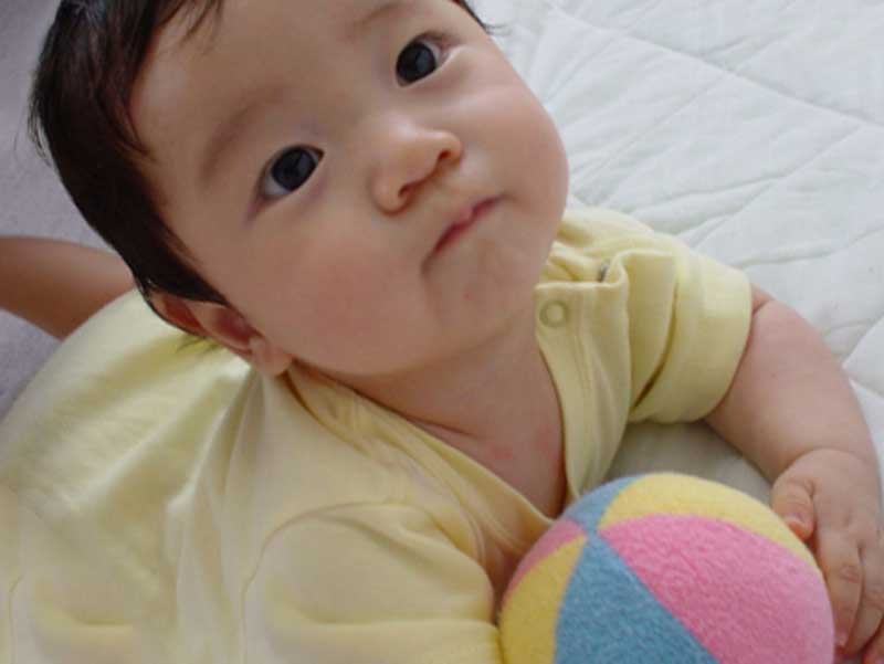 色付きのおもちゃを遊んでいる赤ちゃん