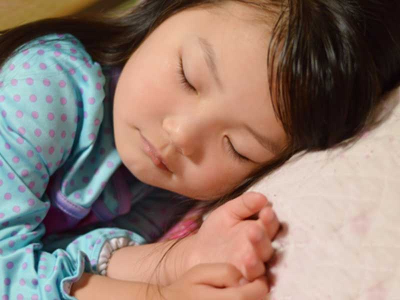枕で寝ている子供
