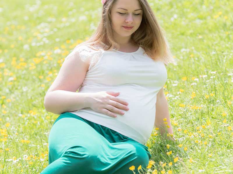 芝の上に座る妊婦さん