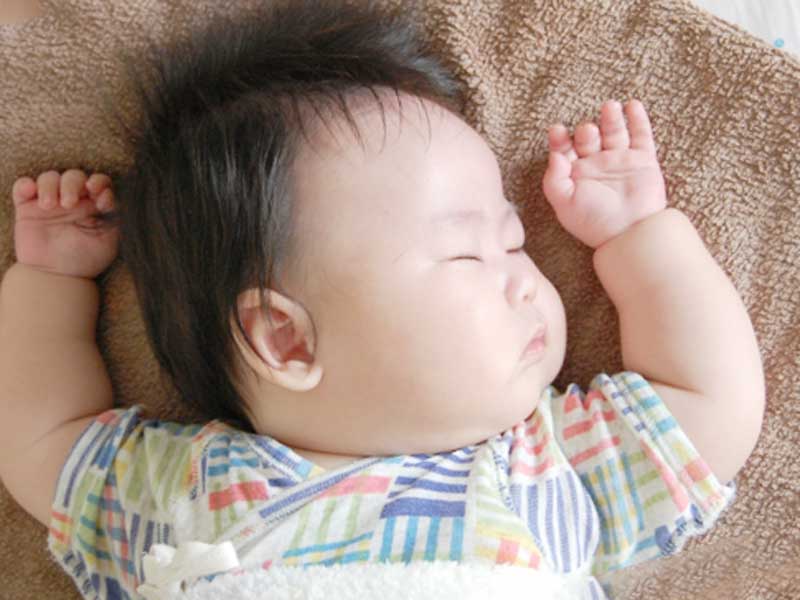 片方のほっぺをつけて寝ている赤ちゃん