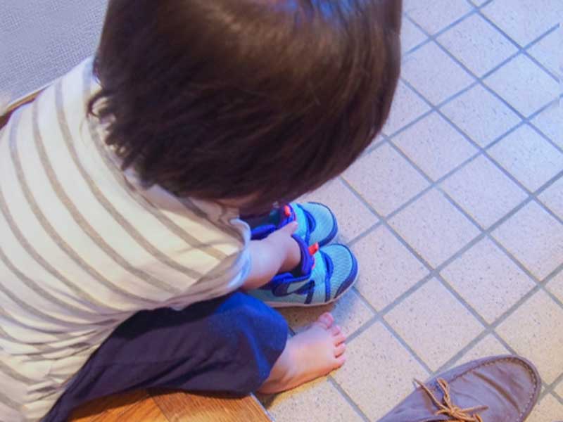 自分で靴を履いている子供