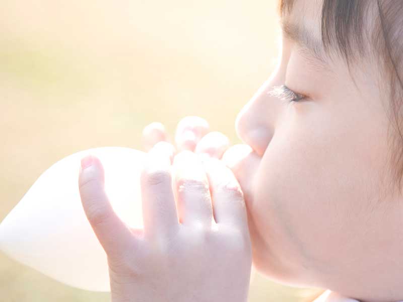 風船を膨らませる子供