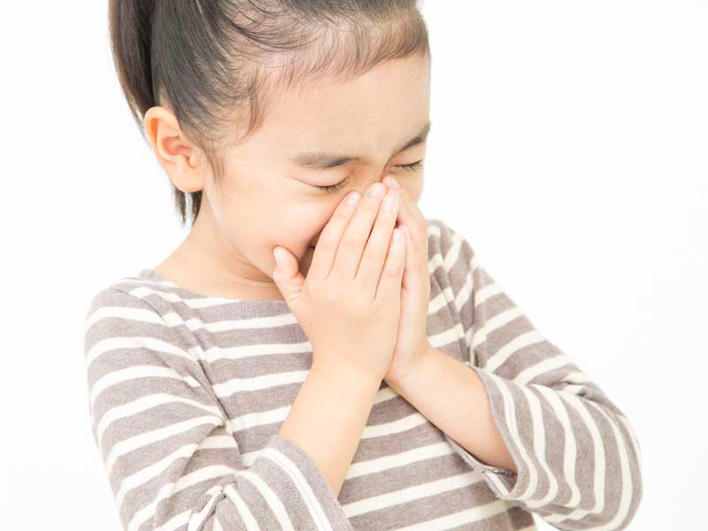 花粉症でくしゃみをしている子供