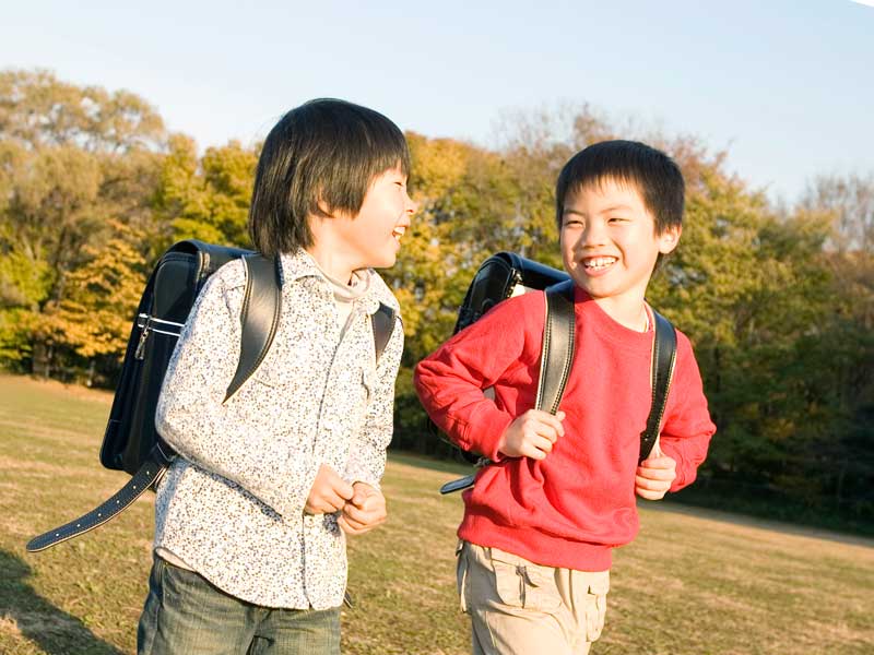 話しながら歩いているランドセルを背負った男の子たち
