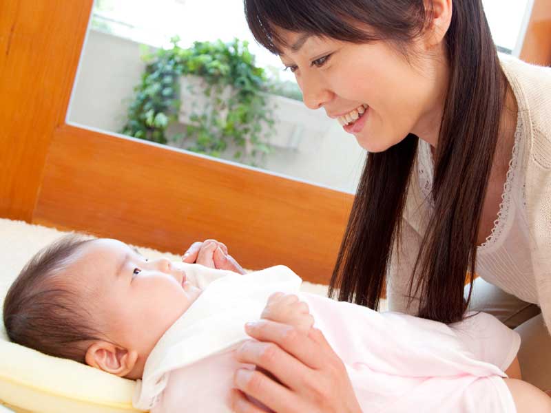 赤ちゃんに微笑みかけているお母さん