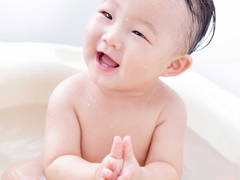 水遊ぶをしている笑顔の赤ちゃん