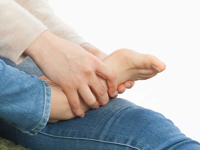 自分で足つぼを押している妊婦さん