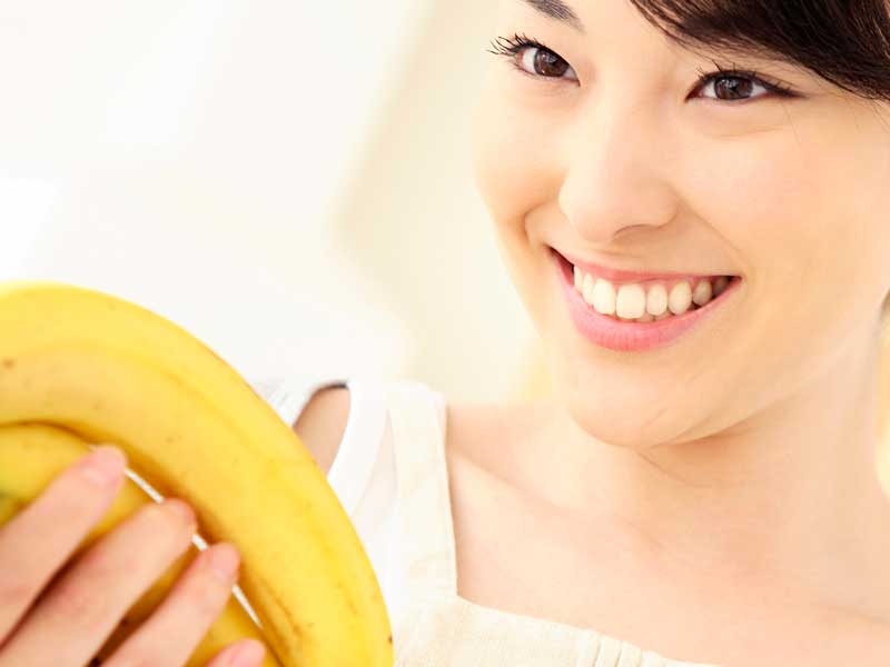 バナナを持つ笑顔の妊婦