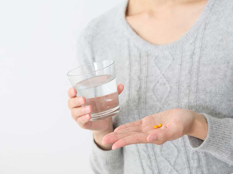 薬を飲む女性