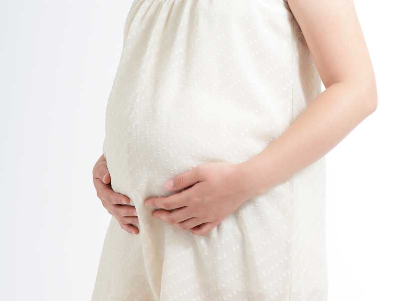 お腹を押さえる妊婦さん