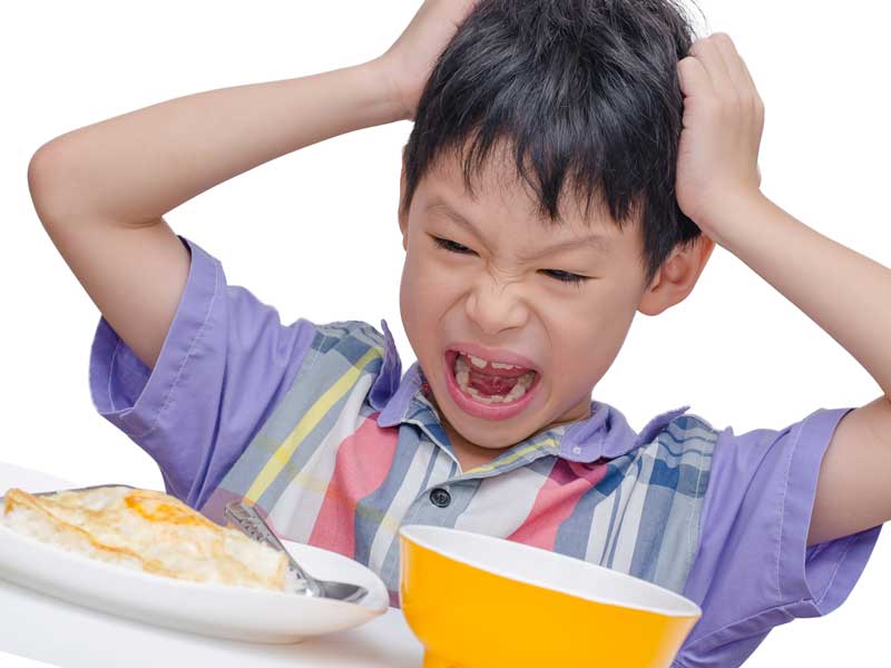 嫌いな物をみて頭をおさえてる偏食の男の子