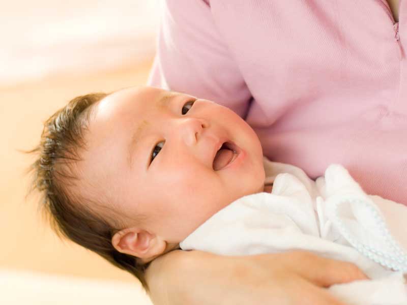 ママに抱っこされている新生児の赤ちゃん