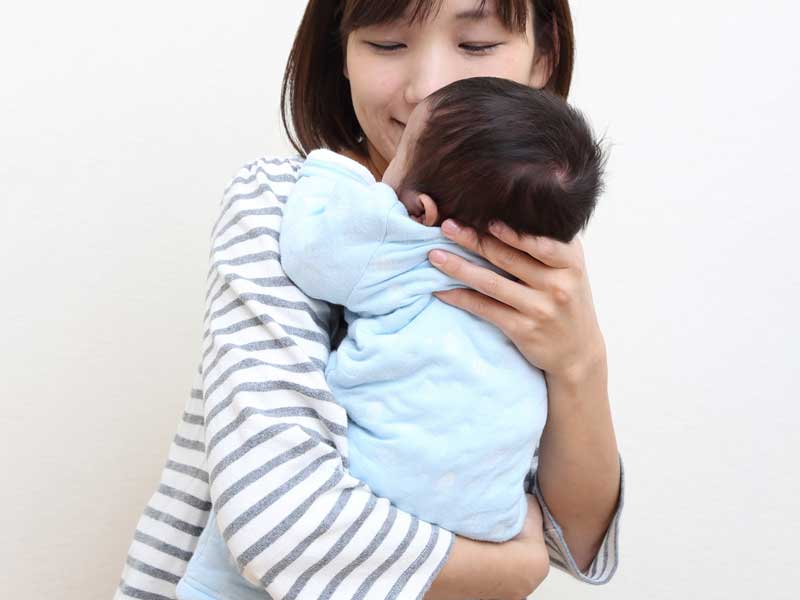 赤ちゃんを縦抱っこしているお母さん