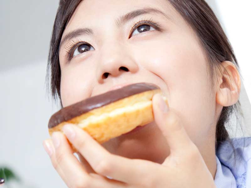 高カロリーのドーナツを食べる妊婦さん