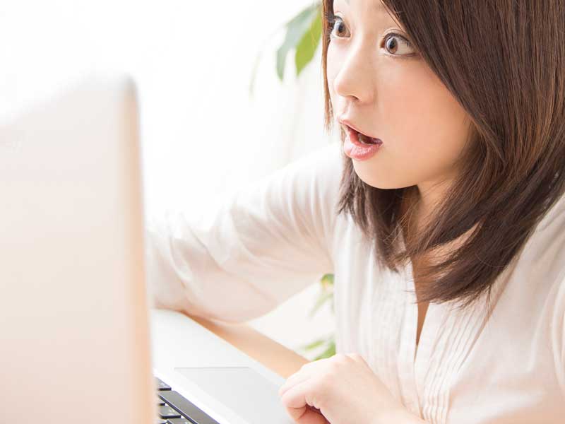 パソコンを見てびっくりする妊婦さん