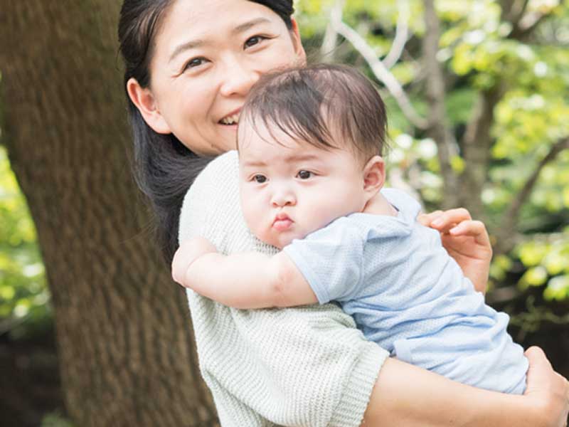 赤ちゃんを連れて散歩するお母さん