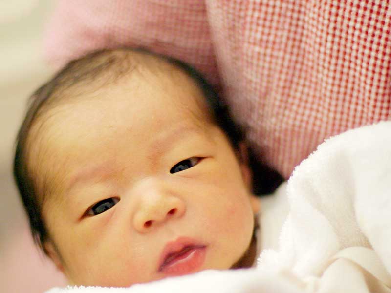 ママに抱っこされている新生児