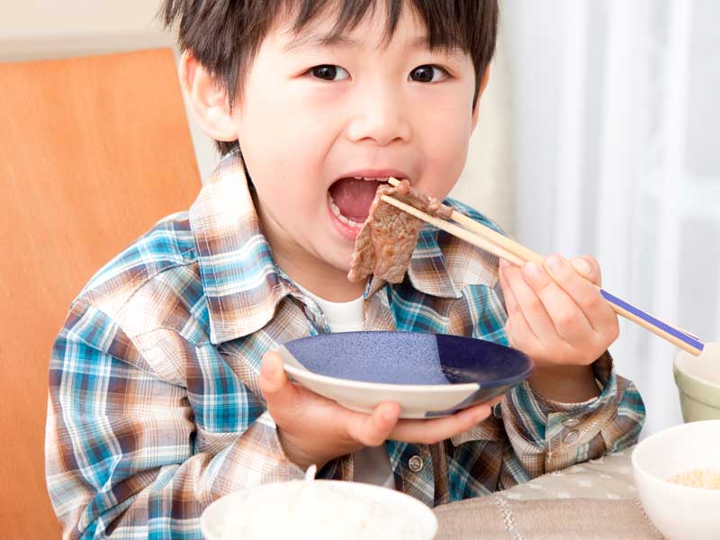 お肉を食べている男の子