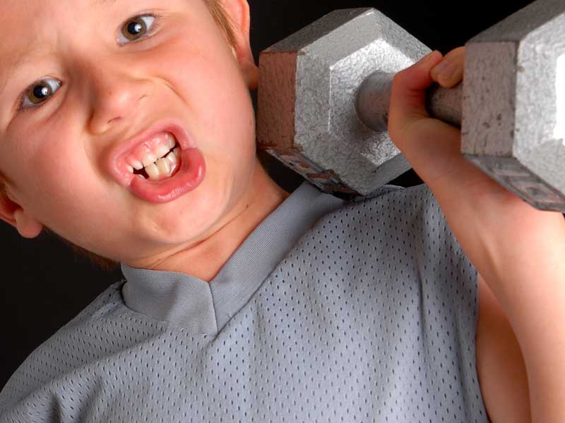 重いダンベルを持つ男の子