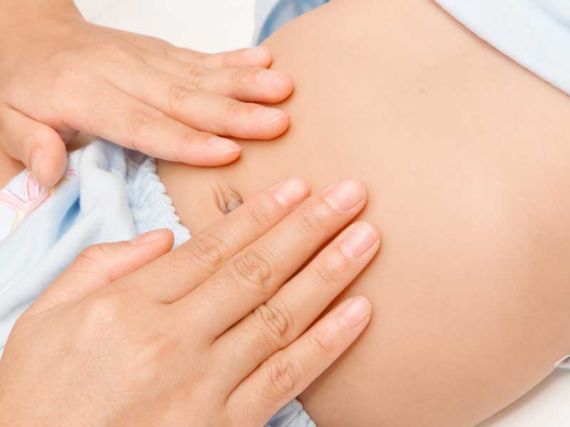 赤ちゃんのお腹を触るママの手