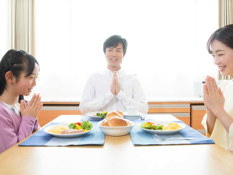 食事をする小学生家族
