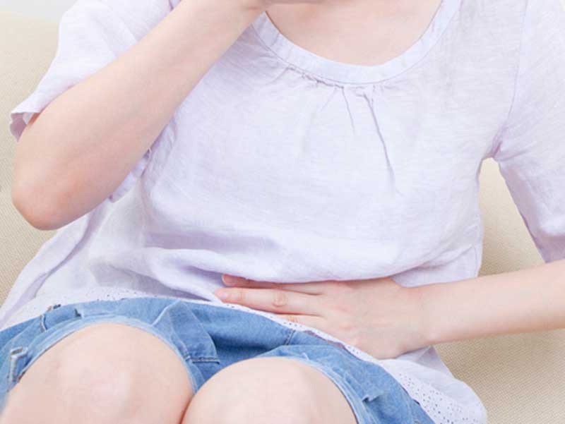 お腹を押さえる女性