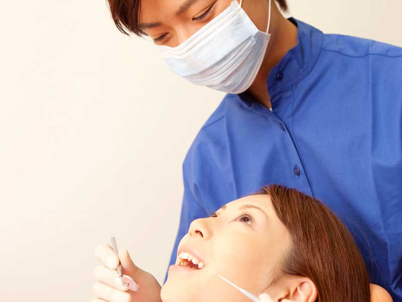 患者に治療をしている歯科医