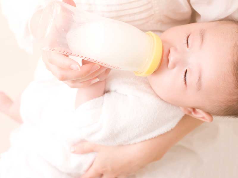 赤ちゃんにミルクを飲ませるママ