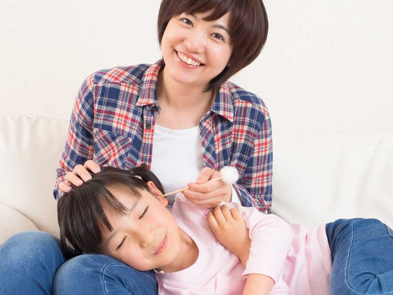 子供に耳掃除をしているママ