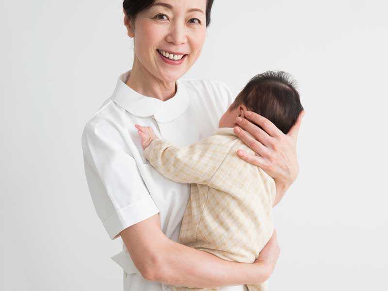 赤ちゃんを抱っこする看護婦さん