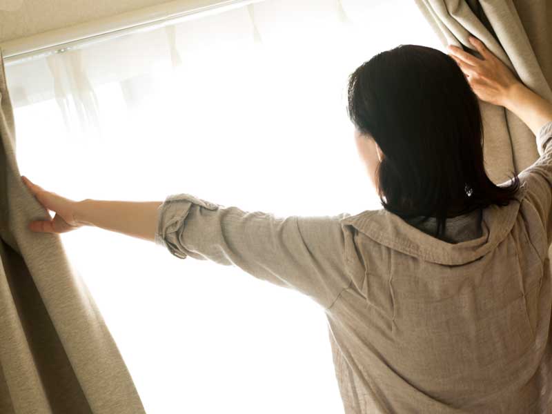 カーテンを開けるお母さん
