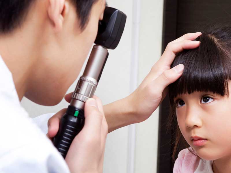 女の子の視力検査する眼科医師