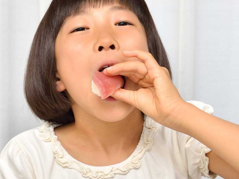 お寿司を食べている女の子