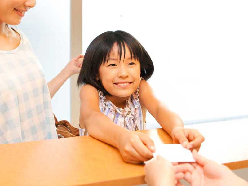受付で保険証を出す女の子