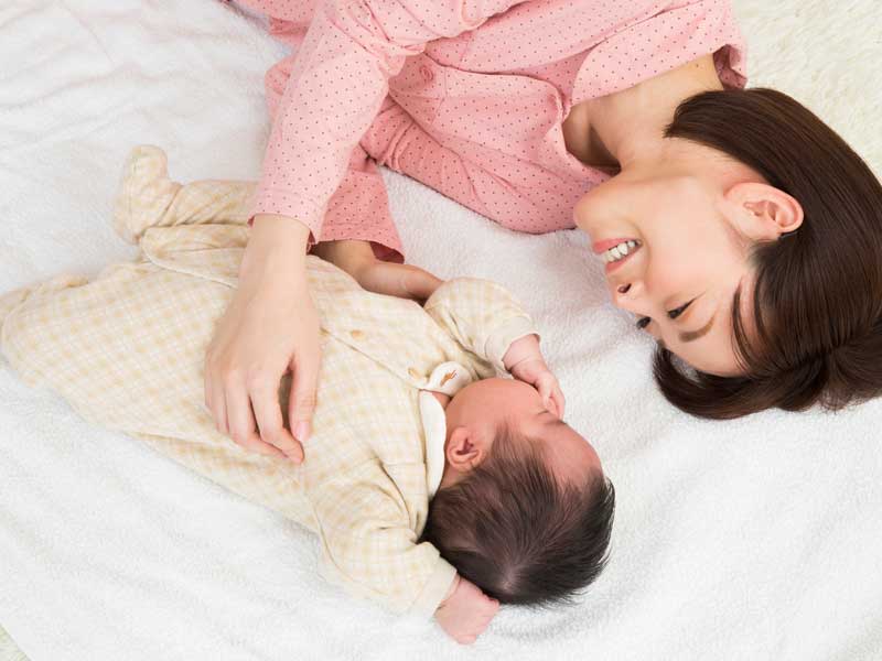 寝転がるお母さんと赤ちゃん