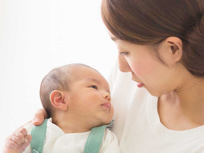 新生児を抱っこするママ