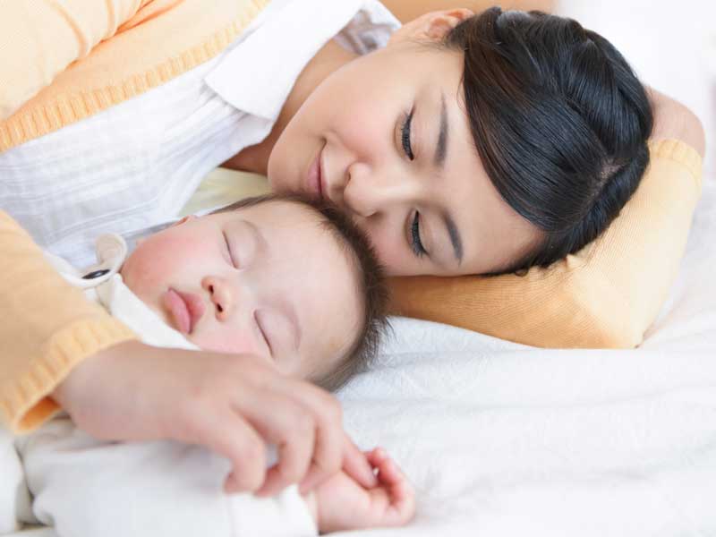 赤ちゃんと一緒に寝るお母さん