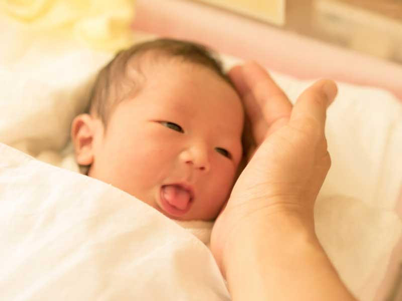 新生児を触るママの手