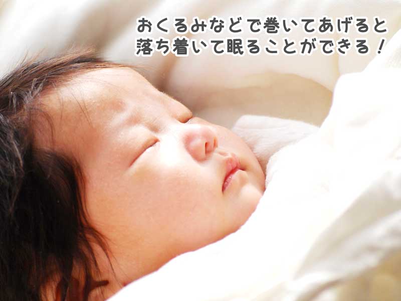 おくるみで巻かれて寝ている新生児