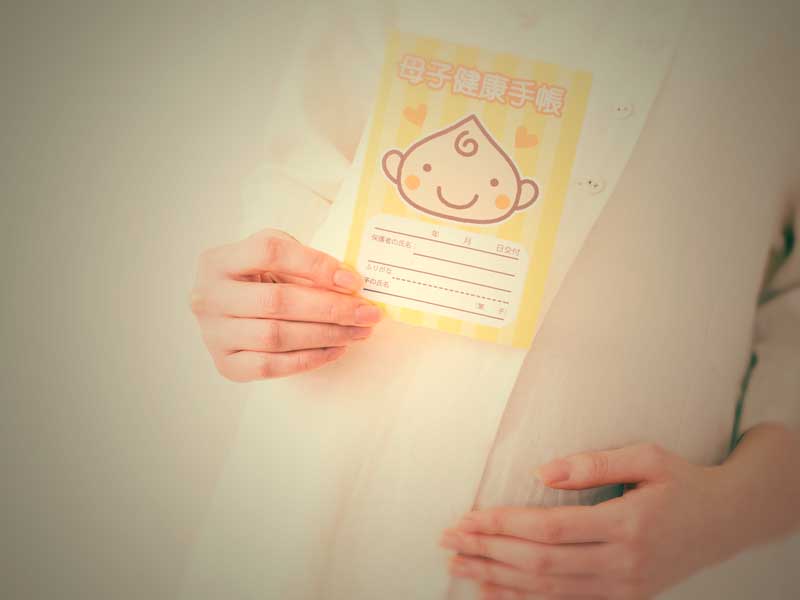 母子手帳を持つ正産期の妊婦さん