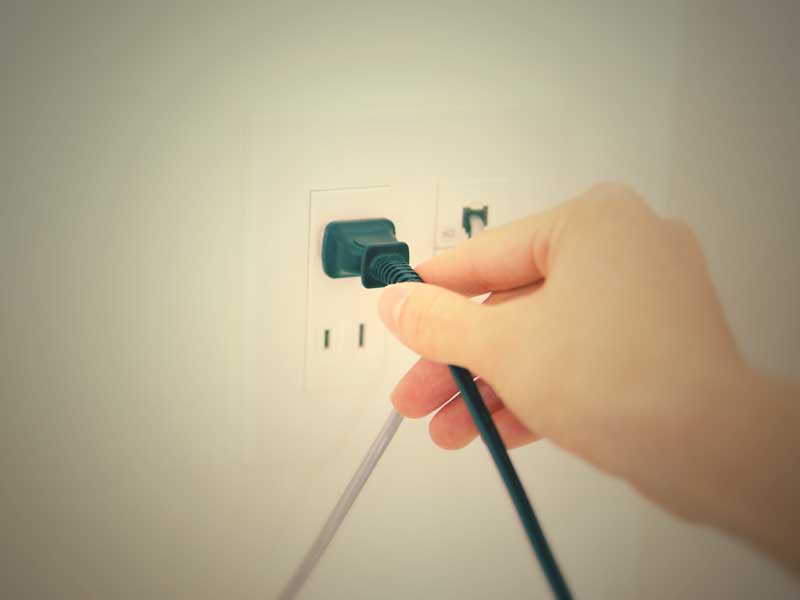 コンセントを挿すママの手