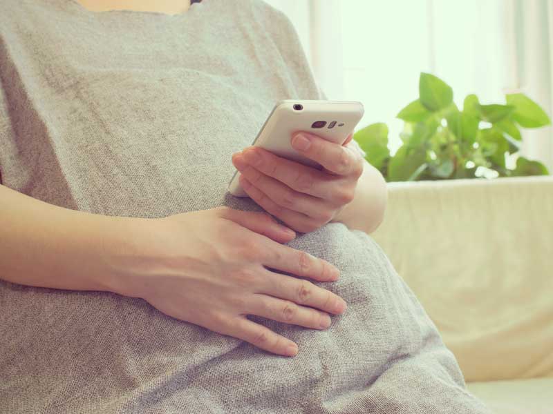 スマホをいじる妊婦さん