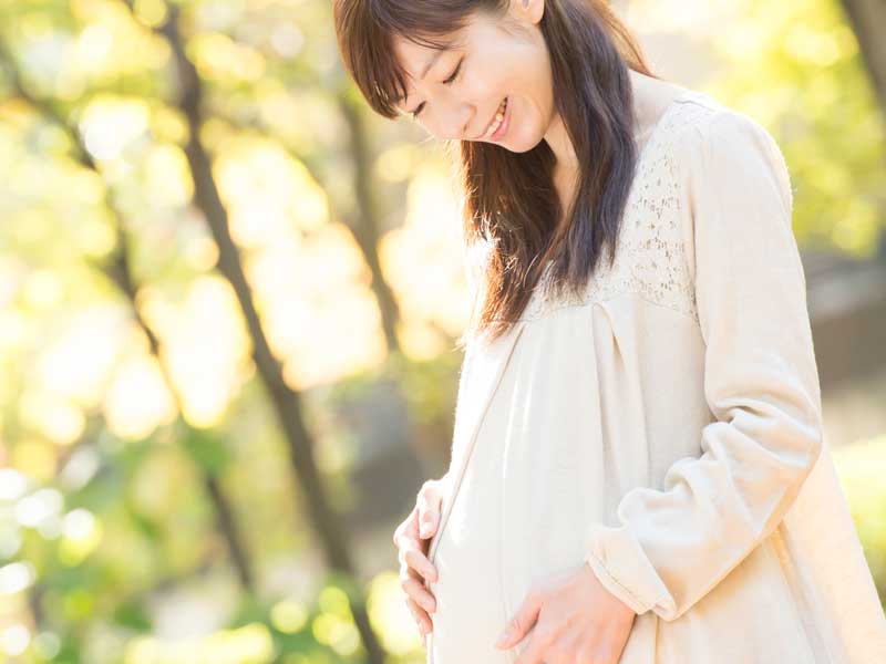 公園で散歩する笑顔の妊婦さん