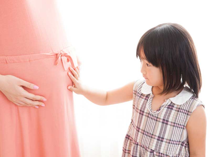ママのお腹を触る女の子