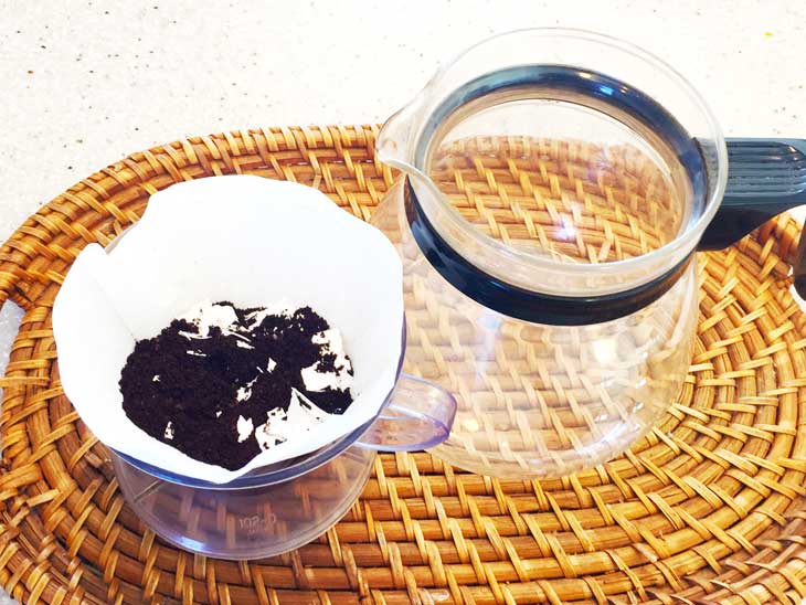 コーヒーフィルターに入ったコーヒーの粉と砕いた卵の殻