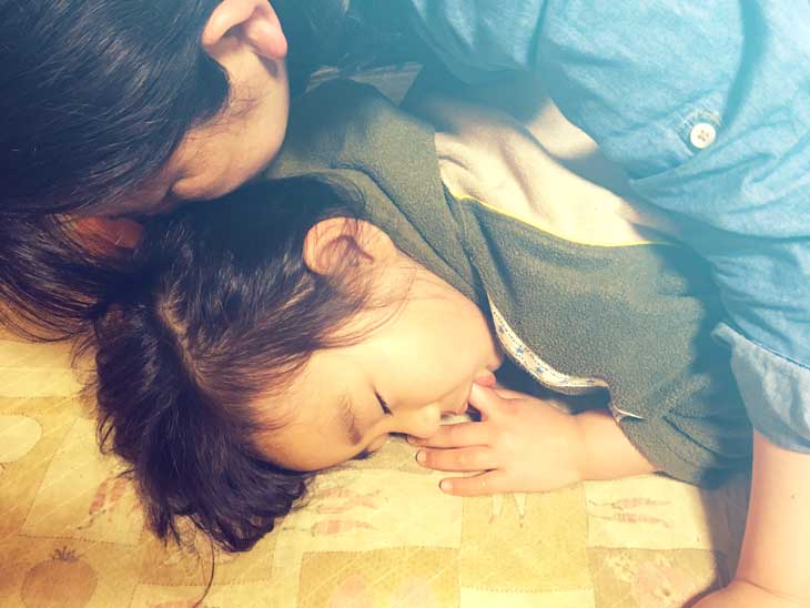 幼児の頭の匂いを嗅ぐ母親
