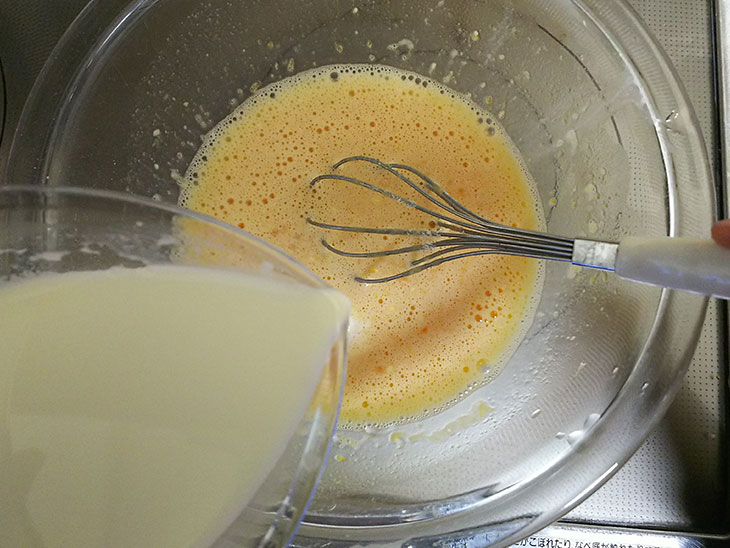 混ぜたカスタードクリームの材料に牛乳を加える様子