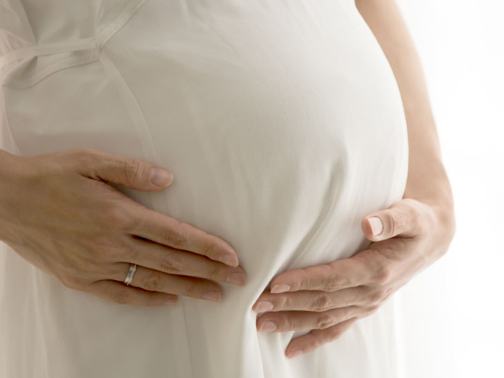 お腹に手を当てる妊婦さん